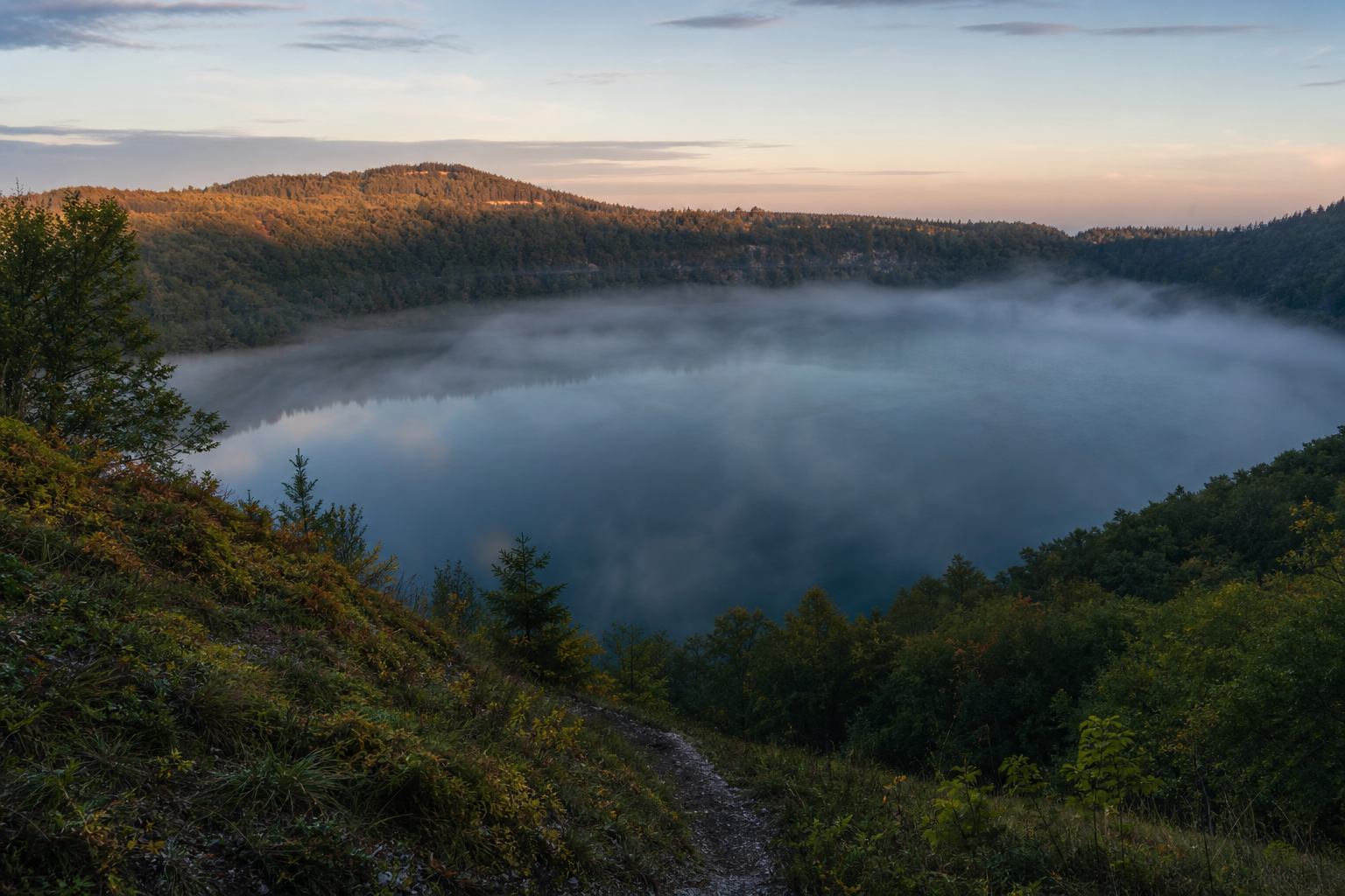 Morgennebel über einem Kratersee in der Vulkaneifel